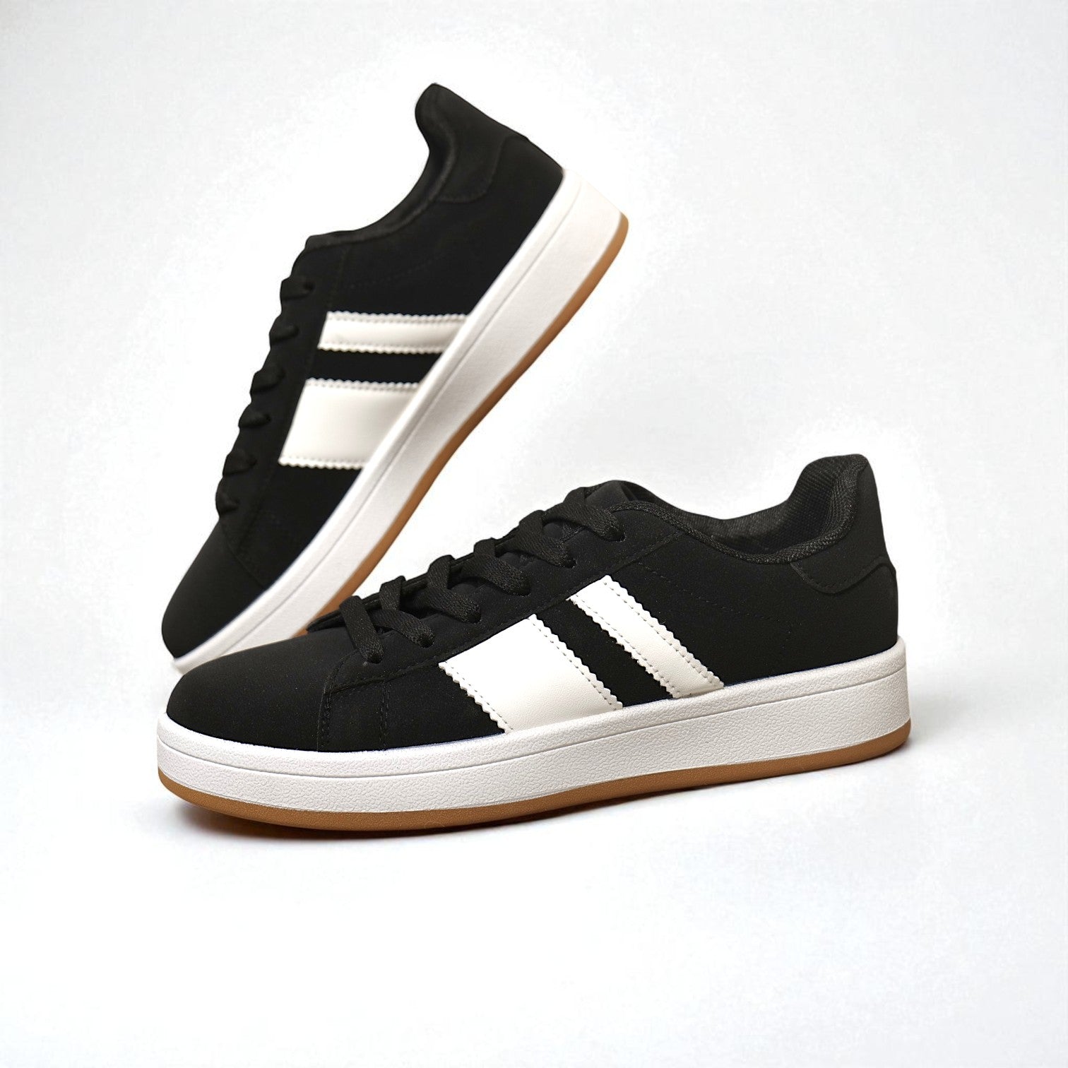 Zapatillas urbanas de mujer estilo skate en color negro con franjas blancas y suela plana de goma
